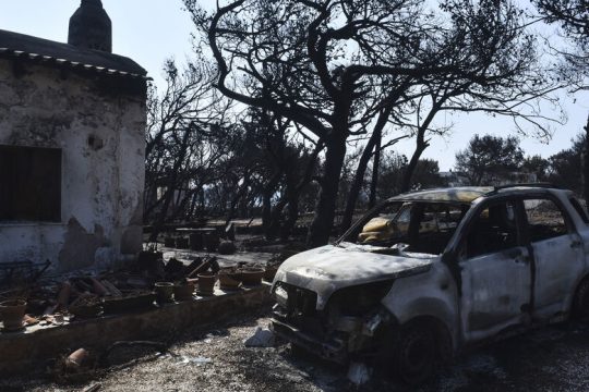 Φωτογραφίες θυμάτων στα έδρανα πίσω από τους κατηγορούμενους στη δίκη για το Μάτι