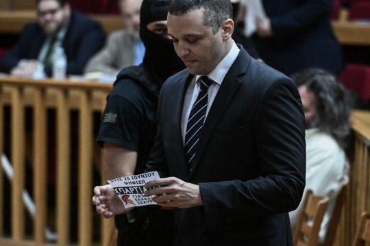 Ο Ηλίας Κασιδιάρης στο δικαστήριο λίγες μέρες πριν από τις εκλογές του Ιουνίου με φέιγ βολάν στήριξης των «Σπαρτιατών» ανά χείρας