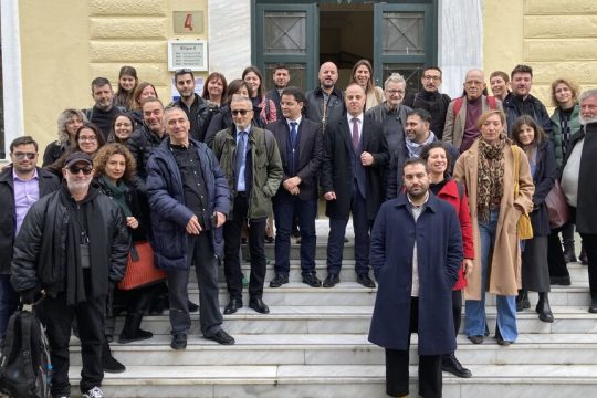 Ρεπόρτερ και ερευνητές της «Εφ.Συν.», των Reporters United και άλλων μέσων, μαζί με αλληλέγγυους, σε αναμνηστική φωτογραφία έξω από το δικαστήριο με τον φακό του Νίκου Πηλού