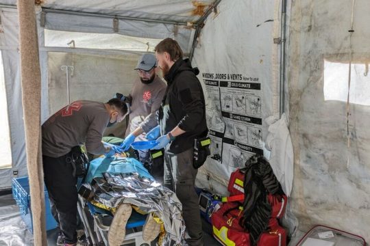 Μέλη της ιατρικής ομάδας της CADUS αφαιρούν σφαίρα από την πλάτη μιας νεαρής γυναίκας