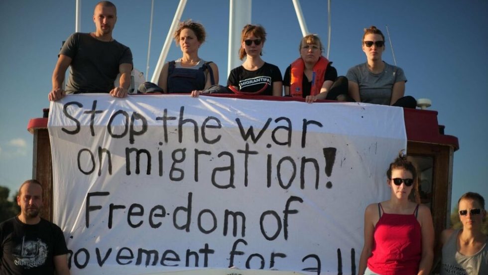 «Σταματήστε τον πόλεμο στη μετανάστευση! Ελεύθερη μετακίνηση για όλους», γράφει το πανό