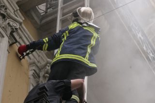 Στιγμιότυπο από την κατάσβεση της πυρκαγιάς στην τράπεζα Marfin, μέσα στην οποία χάθηκαν τρεις εργαζόμενοι κατά τη διάρκεια μαζικής απεργιακής, αντιμνημονιακής πορείας τον Μάιο του 2010