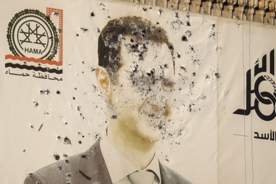 Γιγαντοαφίσα του Μπασάρ αλ Ασαντ στη Χάμα της Συρίας με μερικές εκατοντάδες σφαίρες από... θιασώτες του