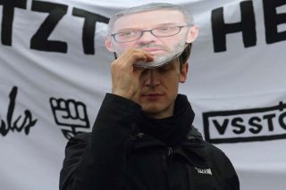Διαδηλωτής στην Αυστρία με μάσκα του ακροδεξιού Χέρμπερτ Κικλ