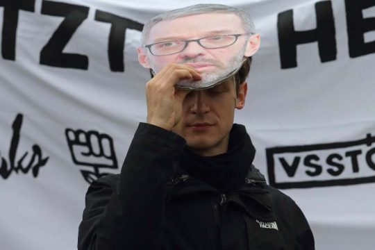 Διαδηλωτής στην Αυστρία με μάσκα του ακροδεξιού Χέρμπερτ Κικλ