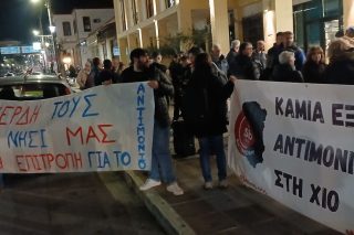 Πολίτες με πανό κατά των σχεδίων εξόρυξης αντιμονίου έξω από το δημαρχείο Χίου κατά τη διάρκεια της επεισοδιακής συνεδρίασης