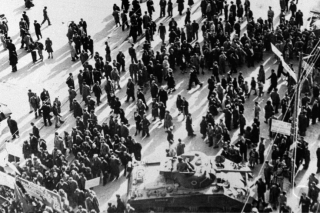 Marching demonstrators come to a halt in University Street, Athens, Dec. 3, 1944, to kneel in prayer in front of the Palace, where ELAS demonstrators were killed