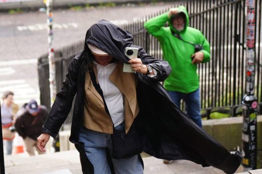 Κάτοικος προσπαθεί να αποφύγει τη βροχή κατά τη διάρκεια της καταιγίδας Scotis