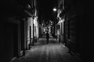 Ανδρας περπατάει σε δρόμο πόλης τη νυχτα