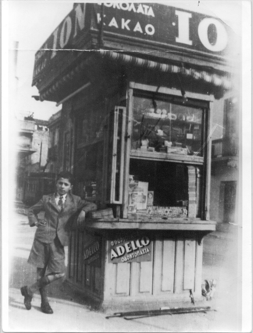 Ο μικρός Δημήτρης Γκιώνης μπροστά στο περίπτερο: στη φωτογραφία αυτή βασίστηκε ο Δήμος Σκουλάκης για το έργο που κόσμησε το εξώφυλλο του βιβλίου «Το Περίπτερο»